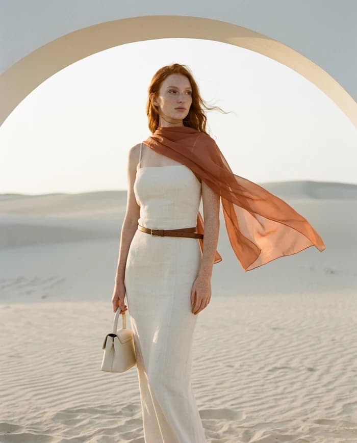 Maren — cream dress and terracotta scarf on desert dunes.
